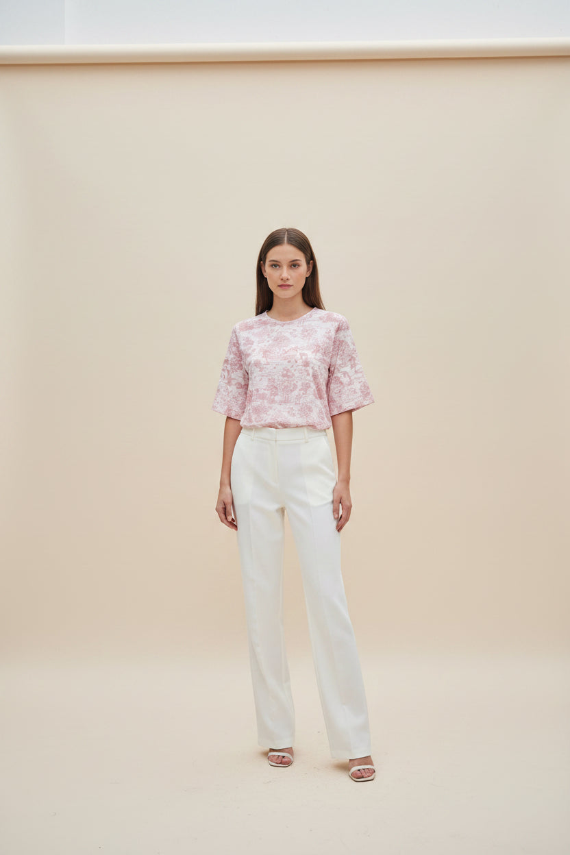 A short-sleeve crewneck top with a pink and beige toile-style landscape print.